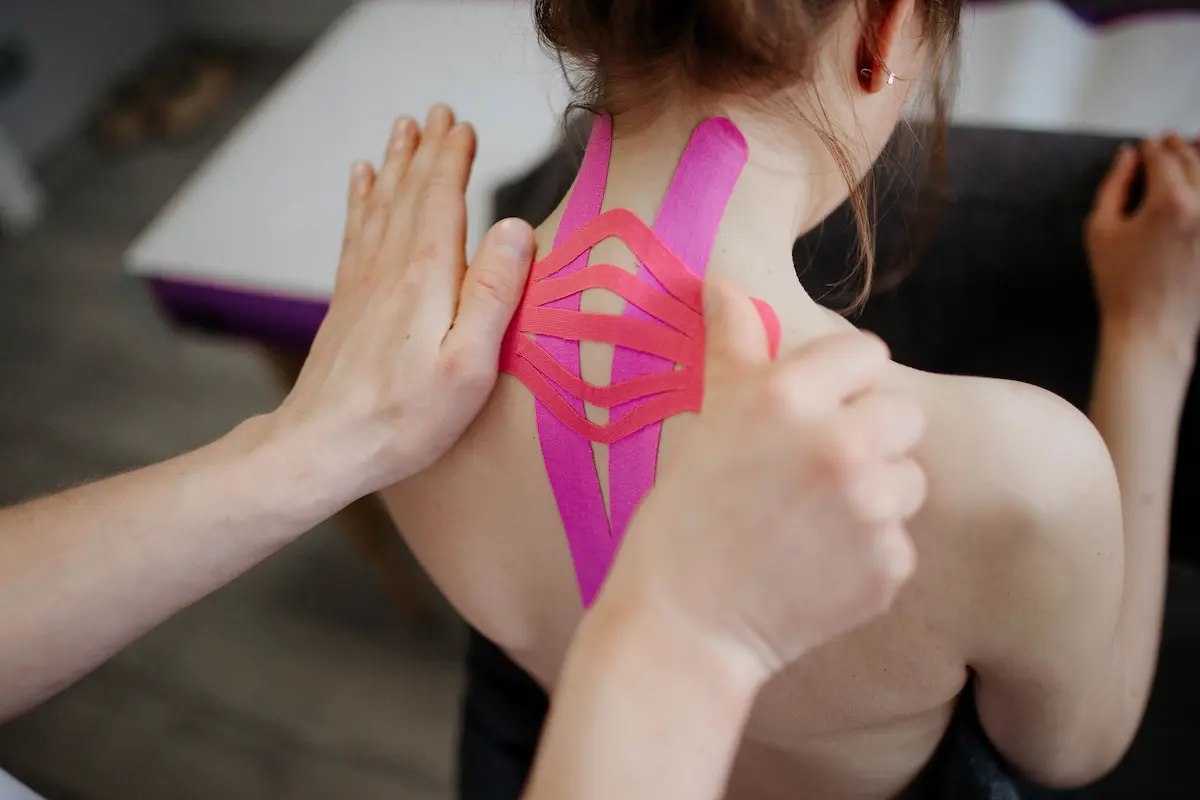 Nærbilde av kinesiotape som påføres ryggen til en person, som viser helsebehandling og terapi