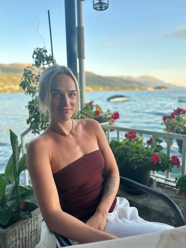 Skaidra gjør en enkel styrkeøkt med en strikk på et lyst hotellrom.