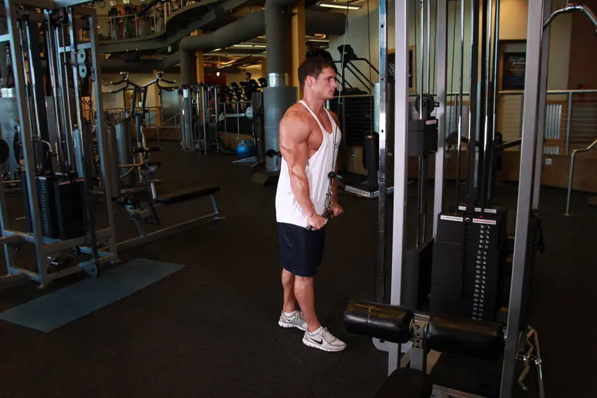 Triceps pushdown sluttposisjon med strake armer og tauet presset ned og litt fra hverandre