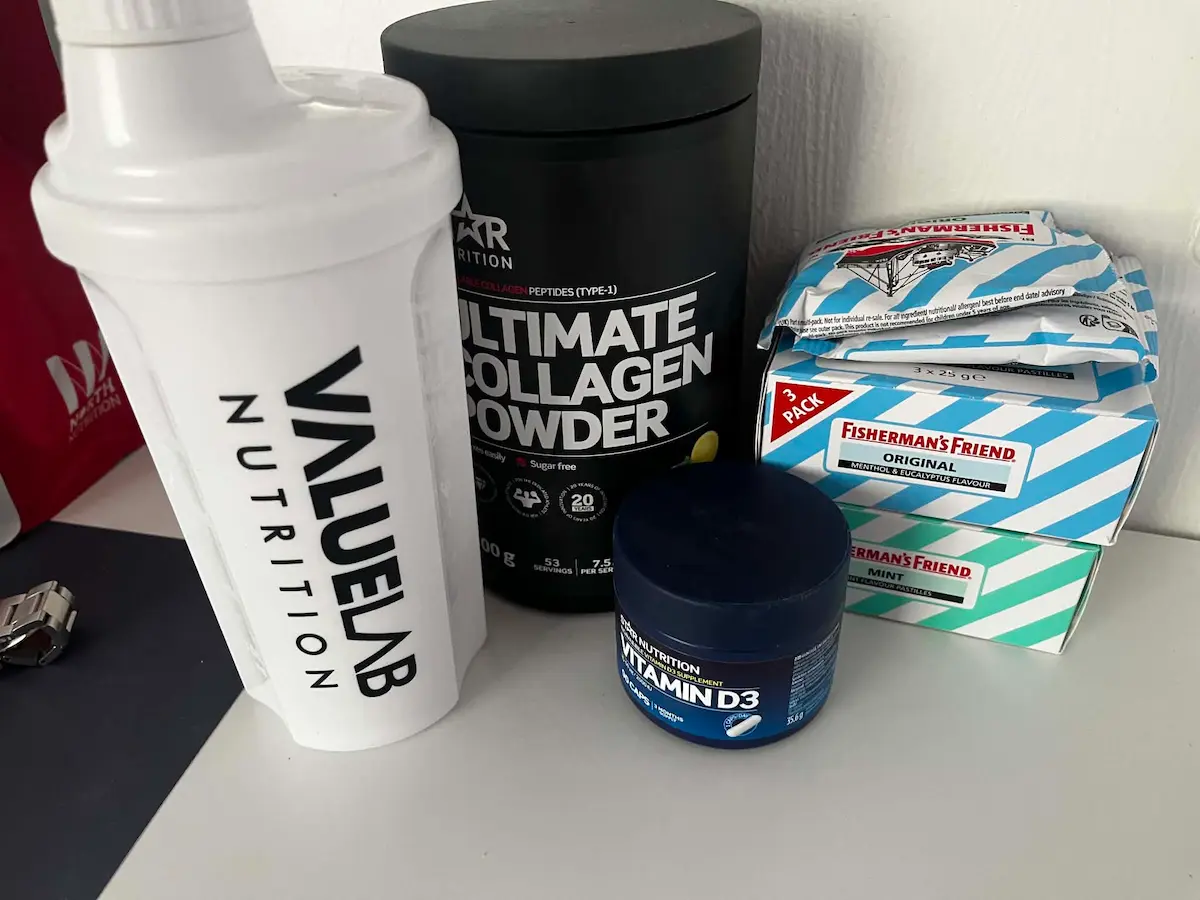 Proteinshake i shaker på kjøkkenbenk ved siden av andre ting.